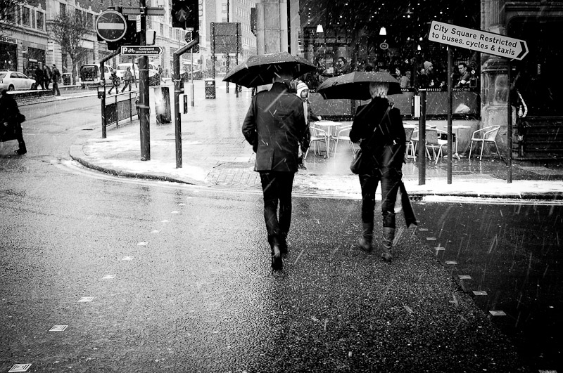 people walking in city centre of leeds in the rain